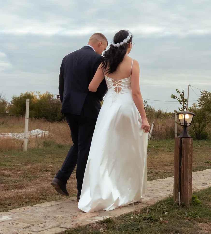 Mladenci hodaju stazom na otvorenom držeći se pod ruku