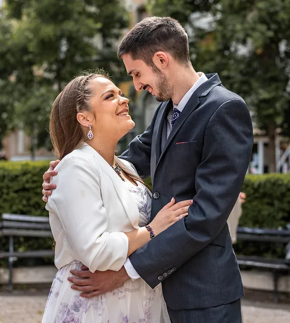 Mladenci se grle i gledaju jedno drugo u parku